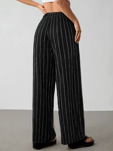 Rückansicht der schwarzen weiten Hose mit weißen Längsstreifen und Gummizug.