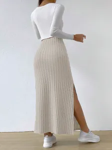 Rear view of a high-waisted beige ribbed knitted maxi skirt with a stylish side slit detail