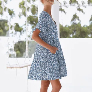 Side view detail of a blue floral summer dress with V-neck and ruffled short sleeves.