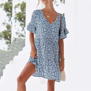 Detail of a blue floral summer dress featuring a V-neckline and feminine ruffle sleeves.