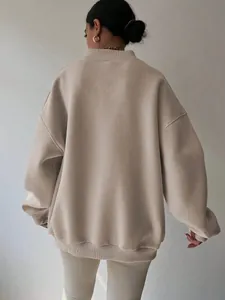Detail view showing the back of an oversized beige crewneck sweatshirt with ribbed texture