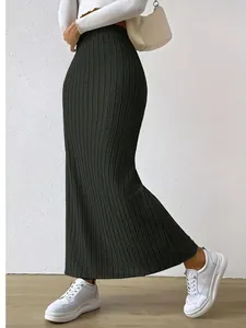 Detailed view of a woman wearing a black high-waisted ribbed knit maxi skirt
