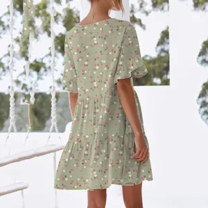 Back view of a sage green floral mini dress featuring ruffle sleeves and a tiered skirt