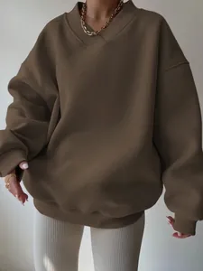 Close-up of women's oversized dark brown casual sweatshirt with ribbed v-neck detail.