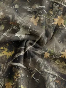 Close-up of breathable mesh fabric with realistic forest camouflage leaf print.
