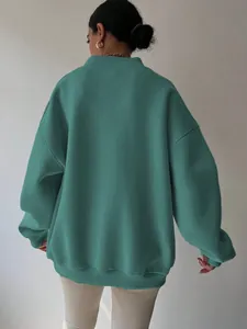 Close-up back view of a teal oversized crewneck sweatshirt for women with ribbed cuffs.