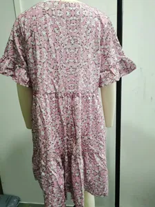 Rear view of a pink floral mini dress with ruffle sleeves displayed on a mannequin.