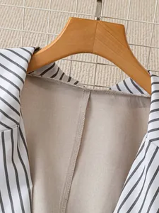 Close-up detail showing the striped lapels and beige lining of a women's British style blazer jacket