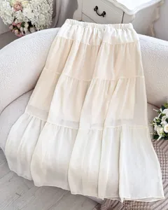 Macro view of a cream French style tiered maxi skirt featuring a delicate layered design