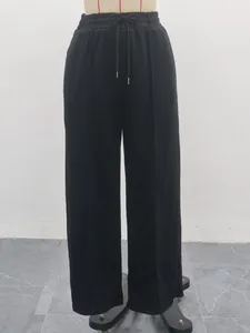Detail of black high-waisted wide-leg sweatpants with adjustable drawstring waistband