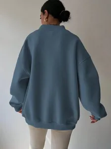 Back view detail of oversized solid blue crewneck sweatshirt showing loose fit.