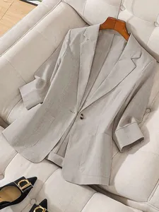 Detailed macro view of women's professional light grey linen-texture blazer with notched lapels