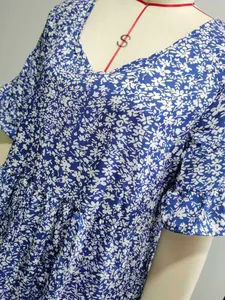 Detail of blue and white floral print dress featuring V-neck and flounce cuff sleeves