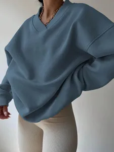 Detail shot of oversized blue V-neck sweatshirt with gold chain accessory