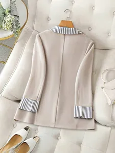 Back view detail of an elegant beige women blazer with striped contrast collar and cuffs