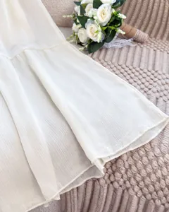 Close-up detail of a white French style long skirt featuring fine pleated chiffon texture
