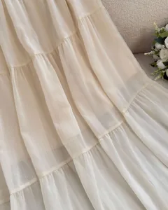 Detailed macro view of French style white tiered chiffon skirt with elegant ruffles.