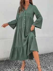 Elegant green tiered midi dress with V-neck and flared sleeves, perfect for summer