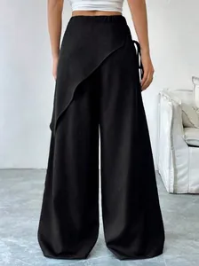 Back view detail of black asymmetrical wide-leg trousers featuring a unique wrap design