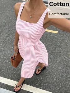 Full view of pink and white striped sleeveless maxi dress in a street setting