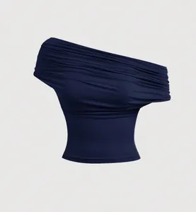 Close-up of the elegant pleated draped detailing on a navy blue off-the-shoulder top