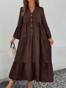 Detailed view of deep brown tiered maxi dress with V-neck button design and bell sleeves