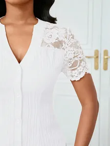 Detailed view of intricate white lace embroidery on the shoulder of a button-up blouse