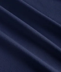 Close-up of navy blue knit fabric showing soft texture and fine stitching detail