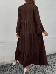 Back view of a tiered coffee brown maxi dress featuring bell sleeves and textured fabric