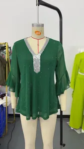 Detailed view of dark green V-neck sequin top with elegant flared ruffle sleeves on mannequin