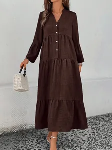 Detailed view of a brown forest style tiered V-neck dress with button front design.