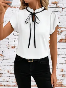Detail showing elegant white pleated collar blouse with black bow tie and ruffle sleeves