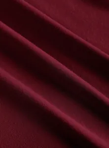 High-quality close-up view of the wine red knitted fabric texture of this stylish top