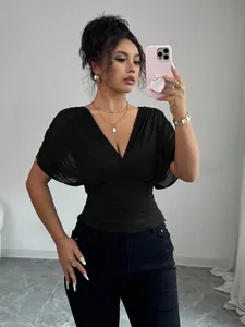 Mirror selfie showing the fit and style of a black deep V-neck flutter sleeve top