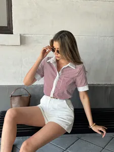 Chic women's red striped polo short sleeve shirt styled with white shorts on a bench