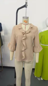 Detailed view of beige V-neck blouse featuring elegant ruffle trim and flared bell sleeves
