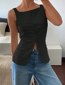 Close-up of black textured sleeveless top with button front and chic slit hem design