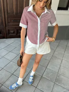 Trendy red and white striped polo shirt and white shorts set for women's casual wear.