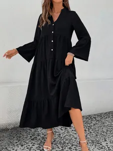 Detailed view of a black tiered MIDI dress with V-neck and bell sleeves on a model.