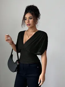 Detail of a chic black deep V-neck flutter sleeve top with a cinched waist design