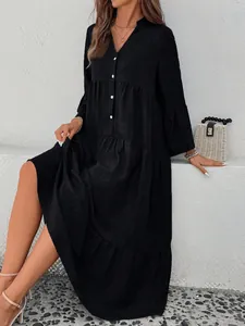 Elegant black V-neck tiered A-line dress with white button detail and flared sleeves.