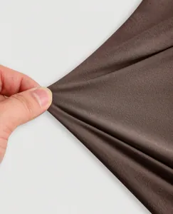 Close-up showing the high elasticity and soft texture of the brown halter top fabric.