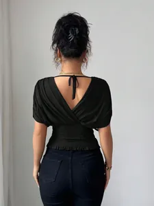 Back view of women's elegant black deep V-neck top featuring smocked waist and bow tie detail
