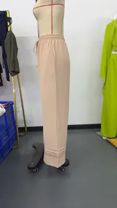 Side view of beige wide-leg trousers featuring textured fabric and hollow-out hem detail
