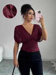Detailed view of wine red deep V-neck top with ruched waist and textured fabric