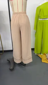 Back view of beige high waist wide leg trousers with textured fabric and lace hem detail