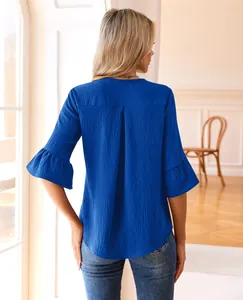 Back view of a royal blue V-neck blouse with elegant bell sleeves and textured fabric