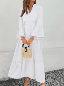 Detail view of a white V-neck tiered midi dress with elegant bell sleeves.