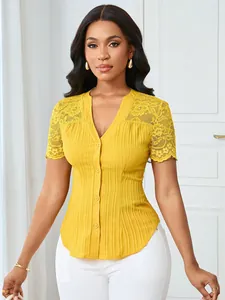 Detailed view of yellow slim-fit blouse with lace embroidery and button-up front