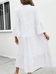 Back view of a white tiered midi dress with elegant flounce bell sleeves.